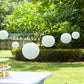 Set of 8 ivory hanging paper lanterns in assorted sizes.