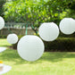 Set of 8 ivory hanging paper lanterns in assorted sizes.