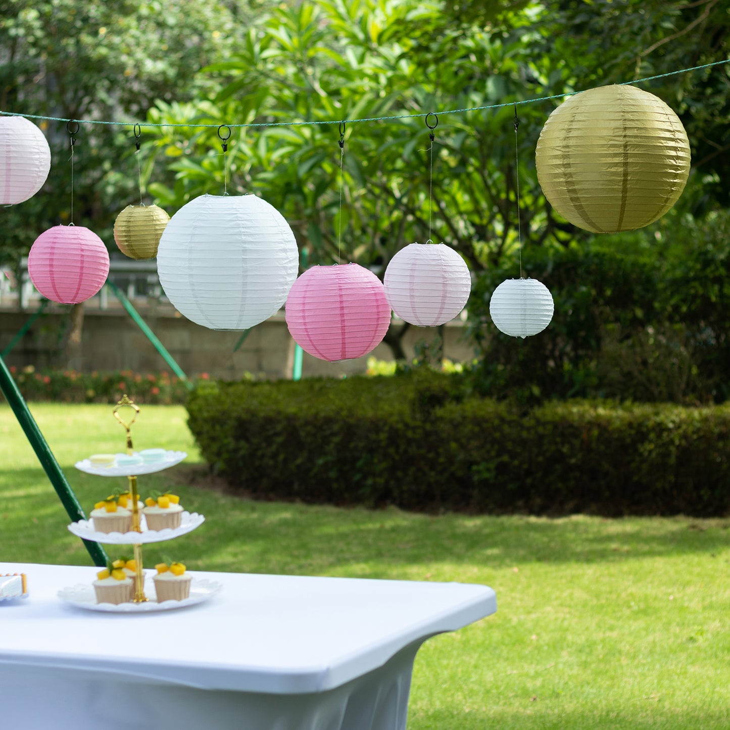 Mixed blush gold hanging paper lanterns in assorted sizes, perfect for decoration.