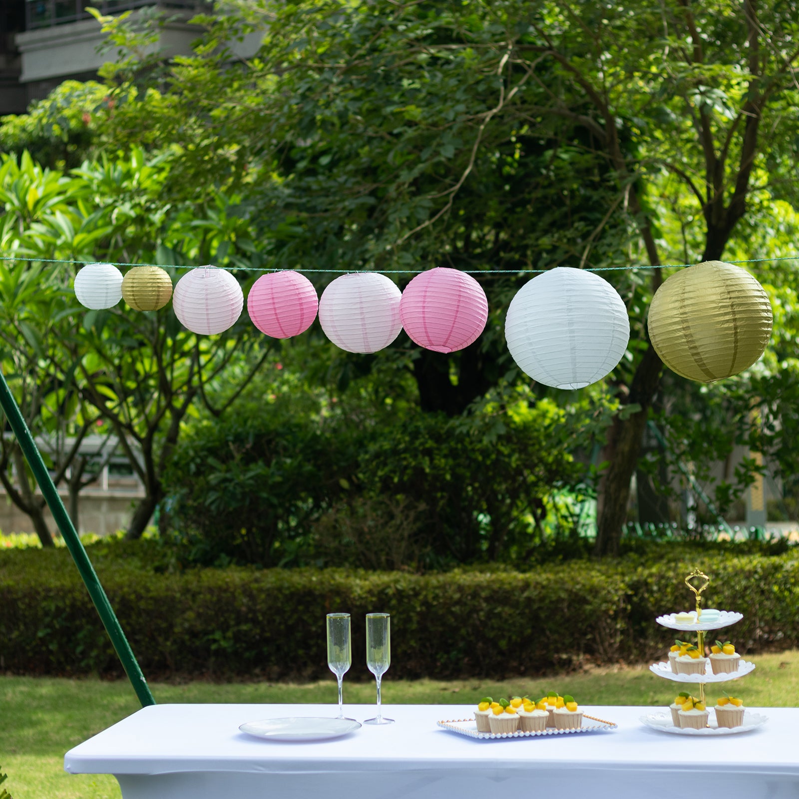 Blush gold hanging paper lanterns in assorted sizes for decoration.