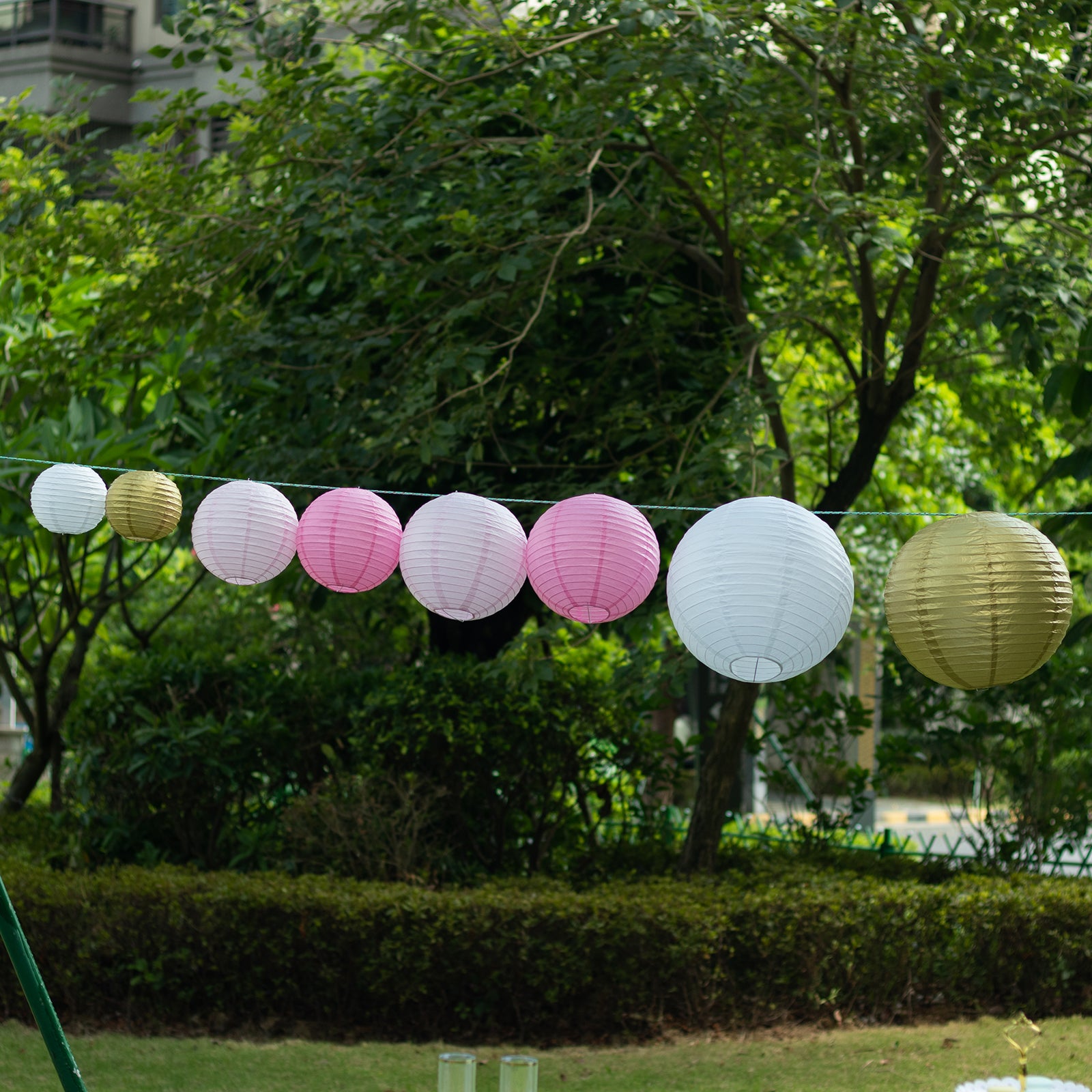 Mixed blush gold hanging paper lanterns in various sizes.