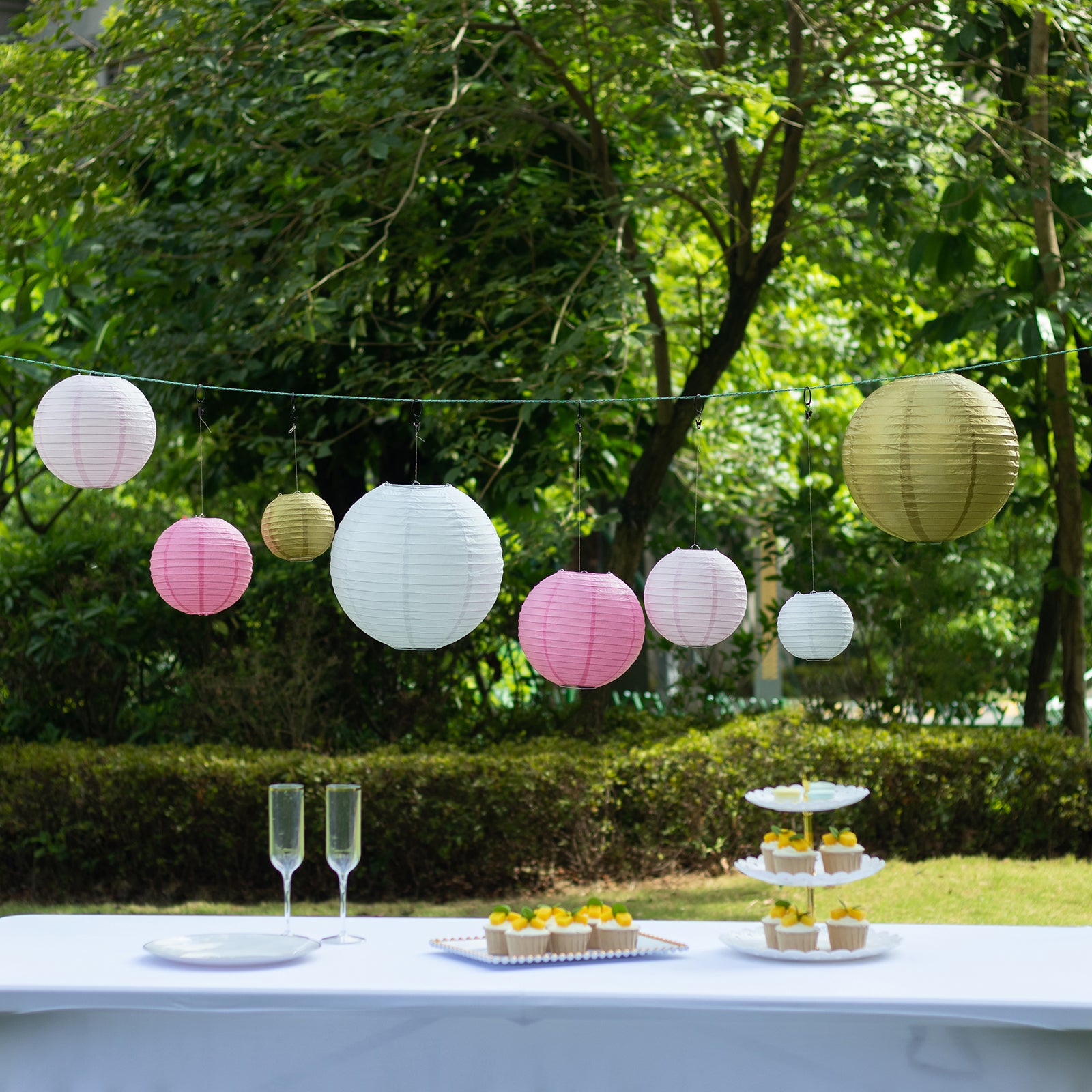 Set of 8 blush gold hanging paper lanterns in assorted sizes.
