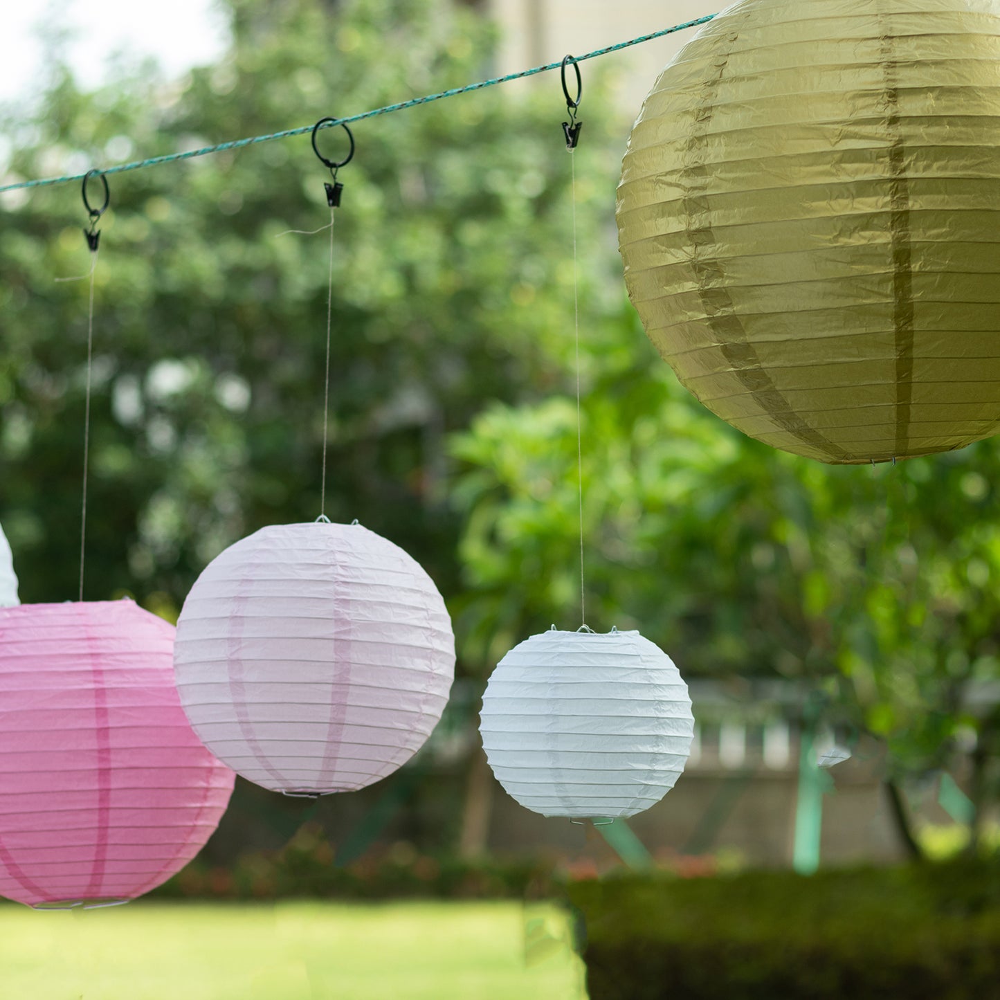 Mixed blush gold hanging paper lanterns in assorted sizes.