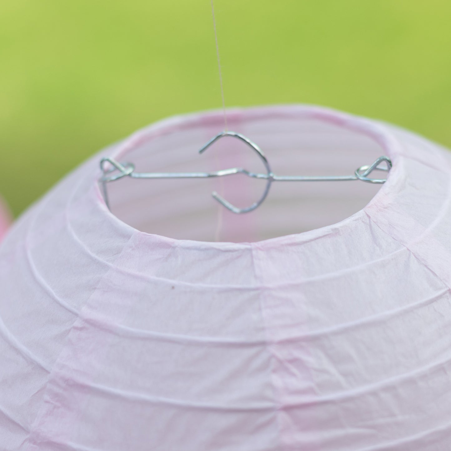 Set of 8 mixed blush gold hanging paper lanterns in assorted sizes.