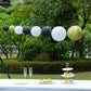 Set of 8 black and gold hanging paper lanterns in assorted sizes.