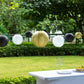 Set of 8 black and gold hanging paper lanterns in assorted sizes.