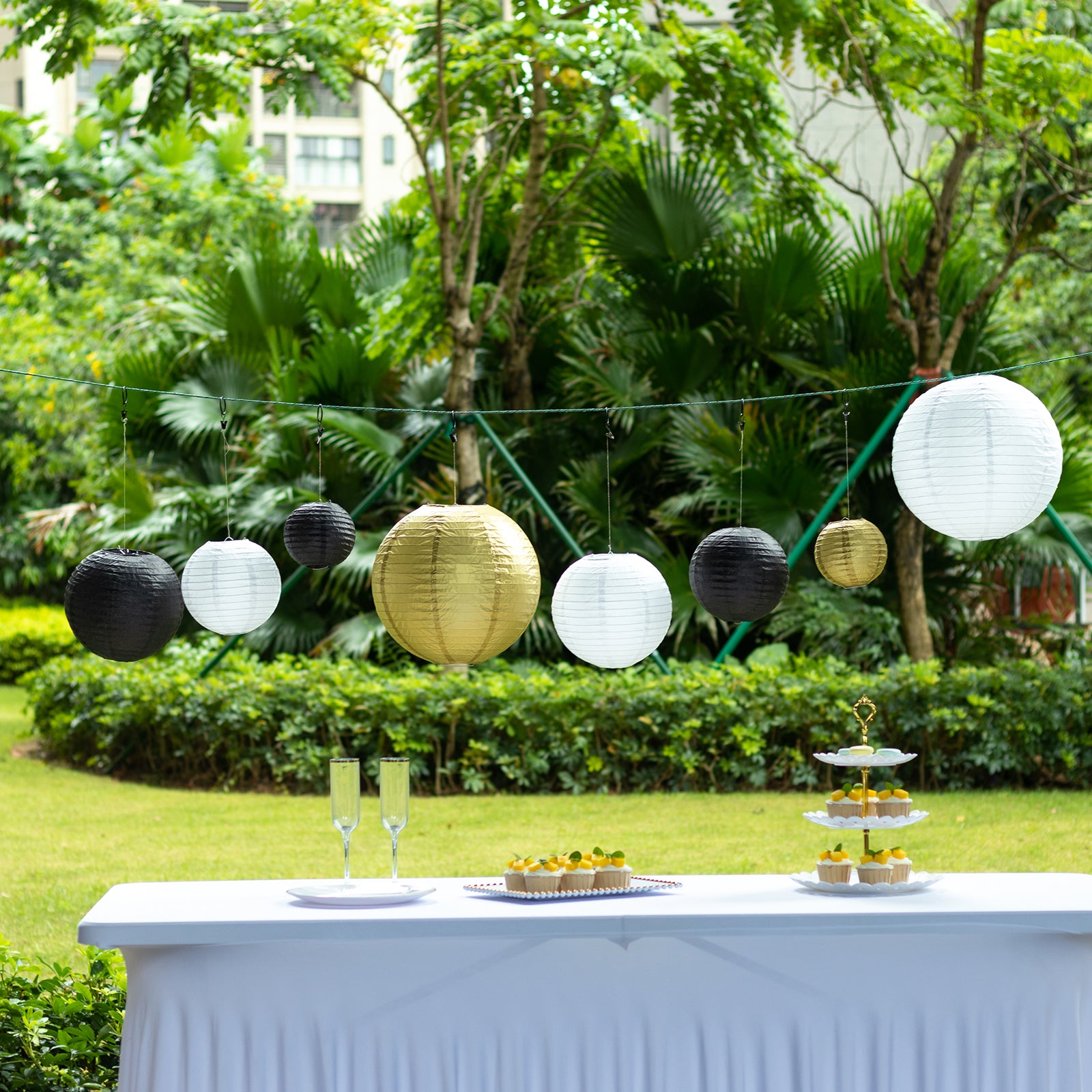 Mixed black and gold hanging paper lanterns in various sizes.