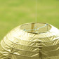 Gold hanging paper lantern with a decorative round shape.