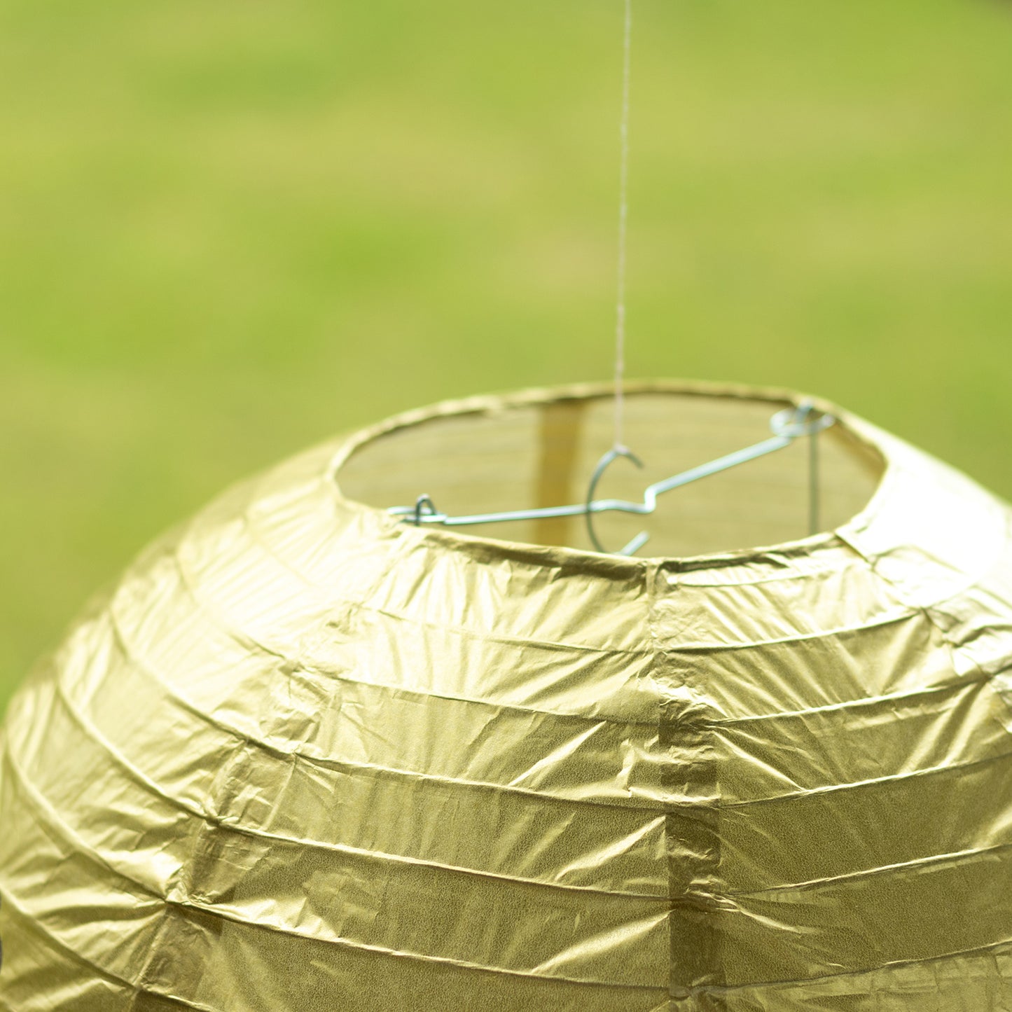 Gold hanging paper lantern with a decorative round shape.