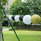 Set of 8 black and gold hanging paper lanterns in various sizes.