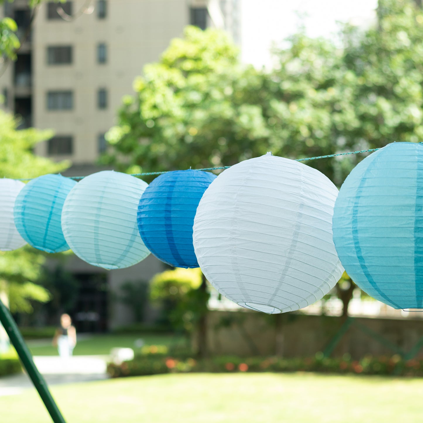 Mixed blue and white hanging paper lanterns in various sizes.