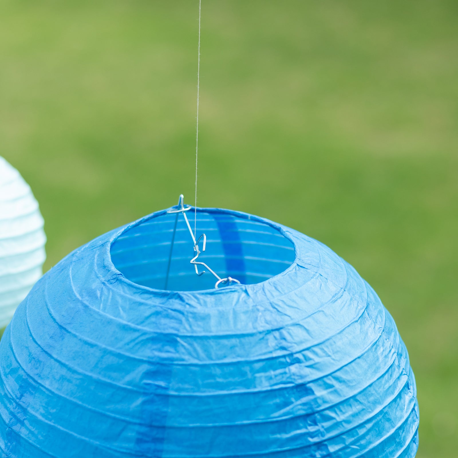 Set of 8 blue and white hanging paper lanterns in various sizes.