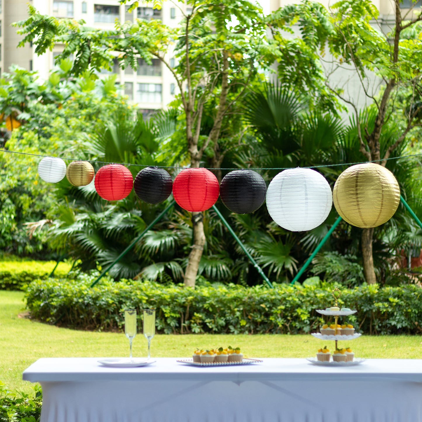 Set of 8 red and gold hanging paper lanterns in assorted sizes.