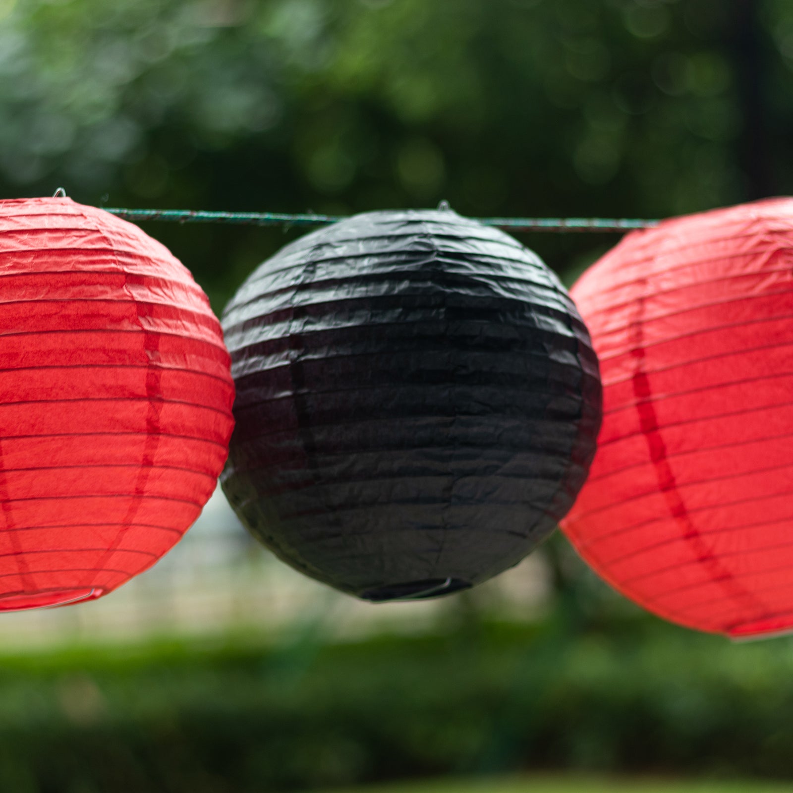Set of 8 red and gold hanging paper lanterns, assorted sizes.
