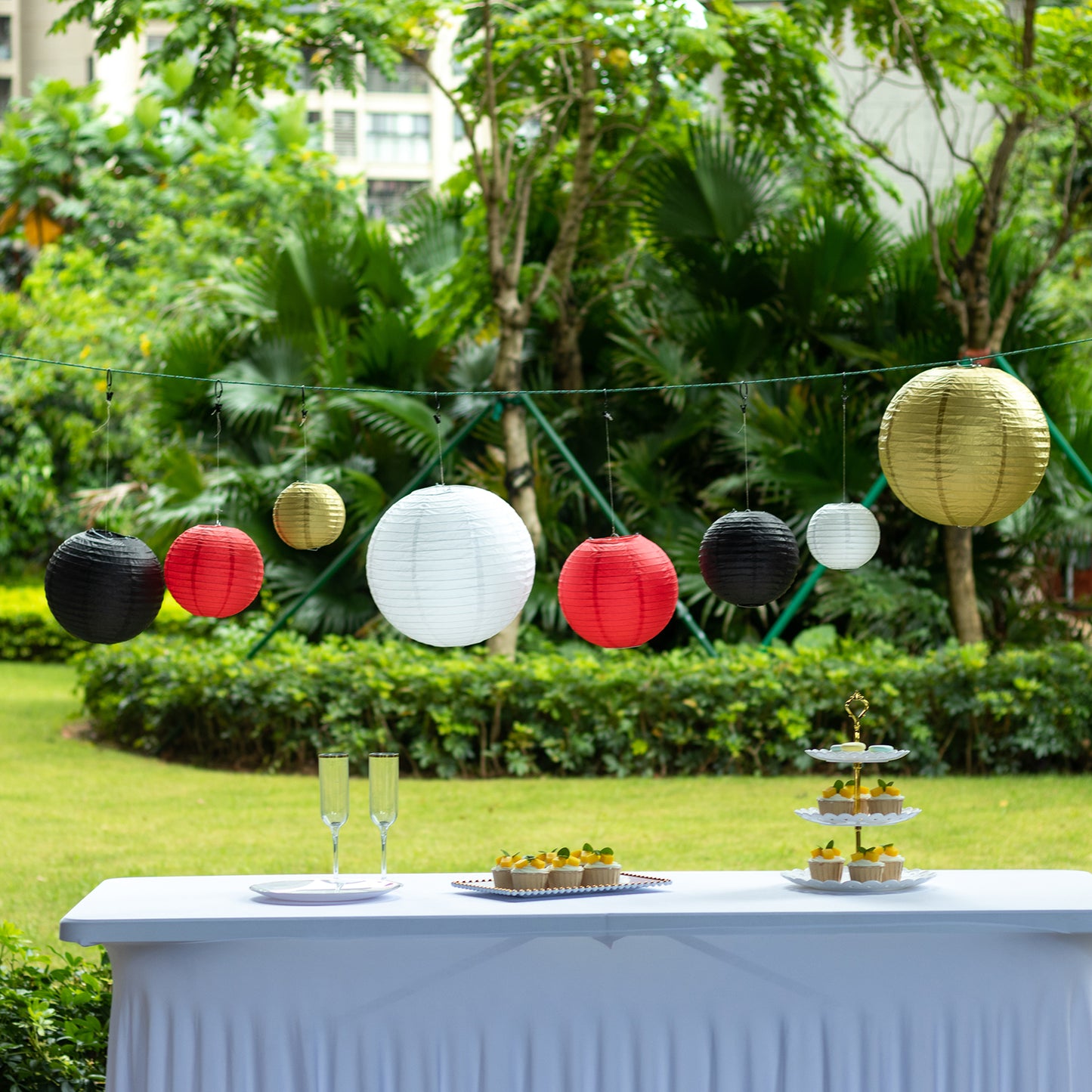 Set of 8 red and gold hanging paper lanterns in assorted sizes.