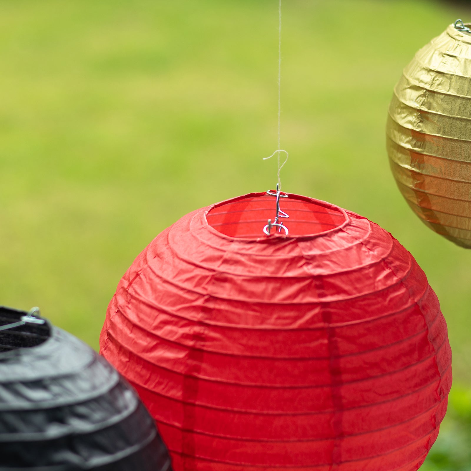 Red and gold hanging paper lanterns in assorted sizes.