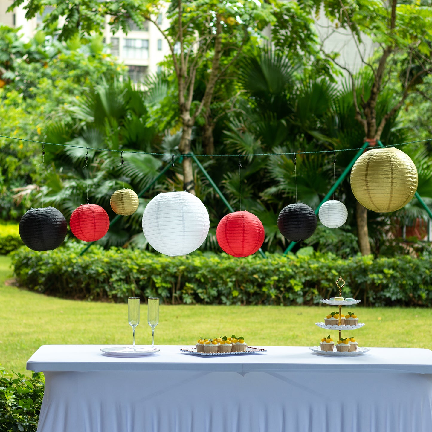 Set of 8 red and gold hanging paper lanterns in assorted sizes.