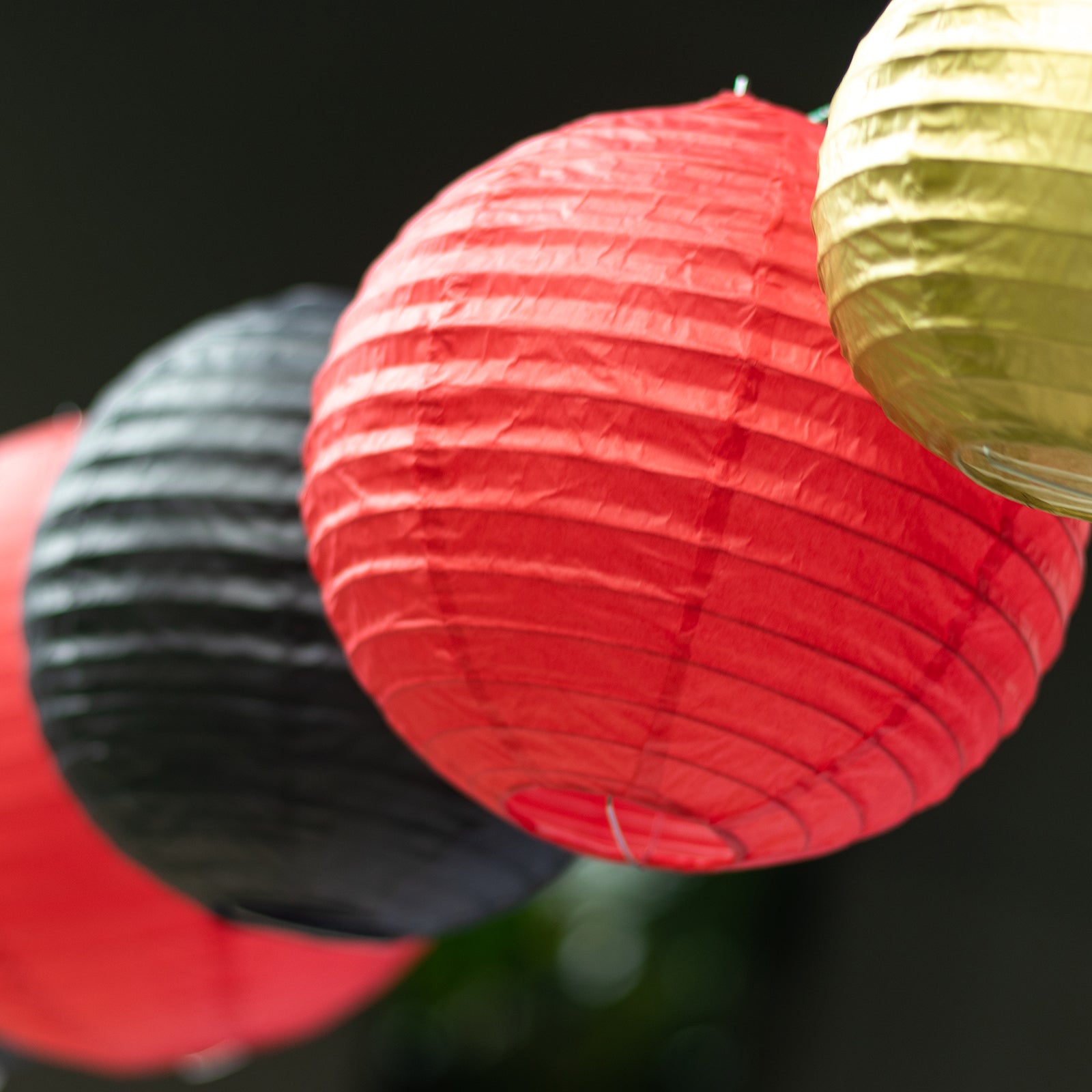 Set of mixed red and gold hanging paper lanterns in assorted sizes.