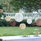 Set of 8 natural brown hanging paper lanterns in assorted sizes.