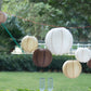 Set of 8 natural brown hanging paper lanterns in assorted sizes.