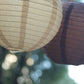 Natural brown hanging paper lanterns in assorted sizes.