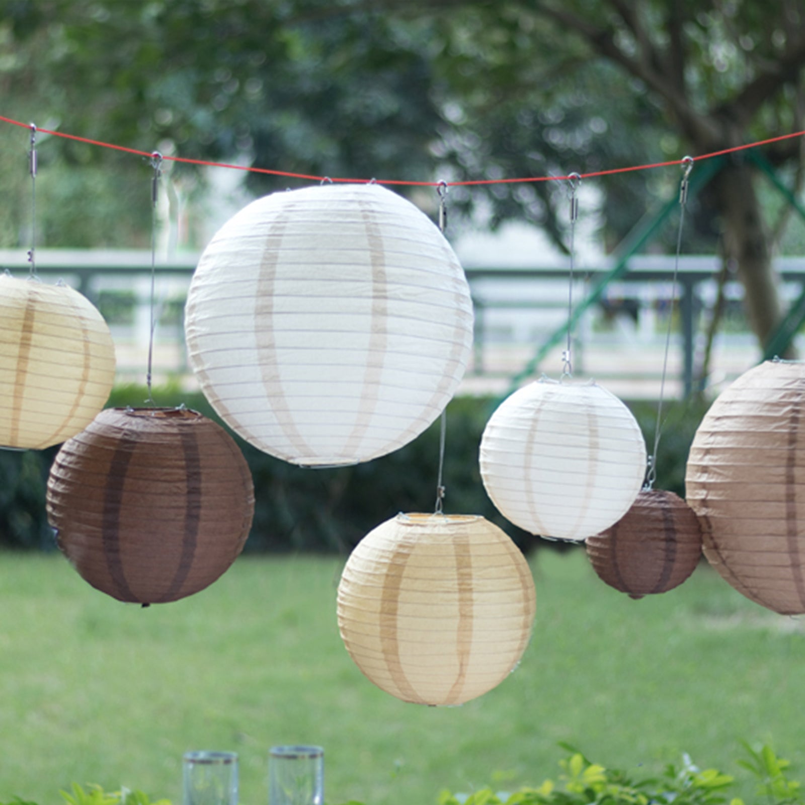 Natural brown hanging paper lanterns in assorted sizes.