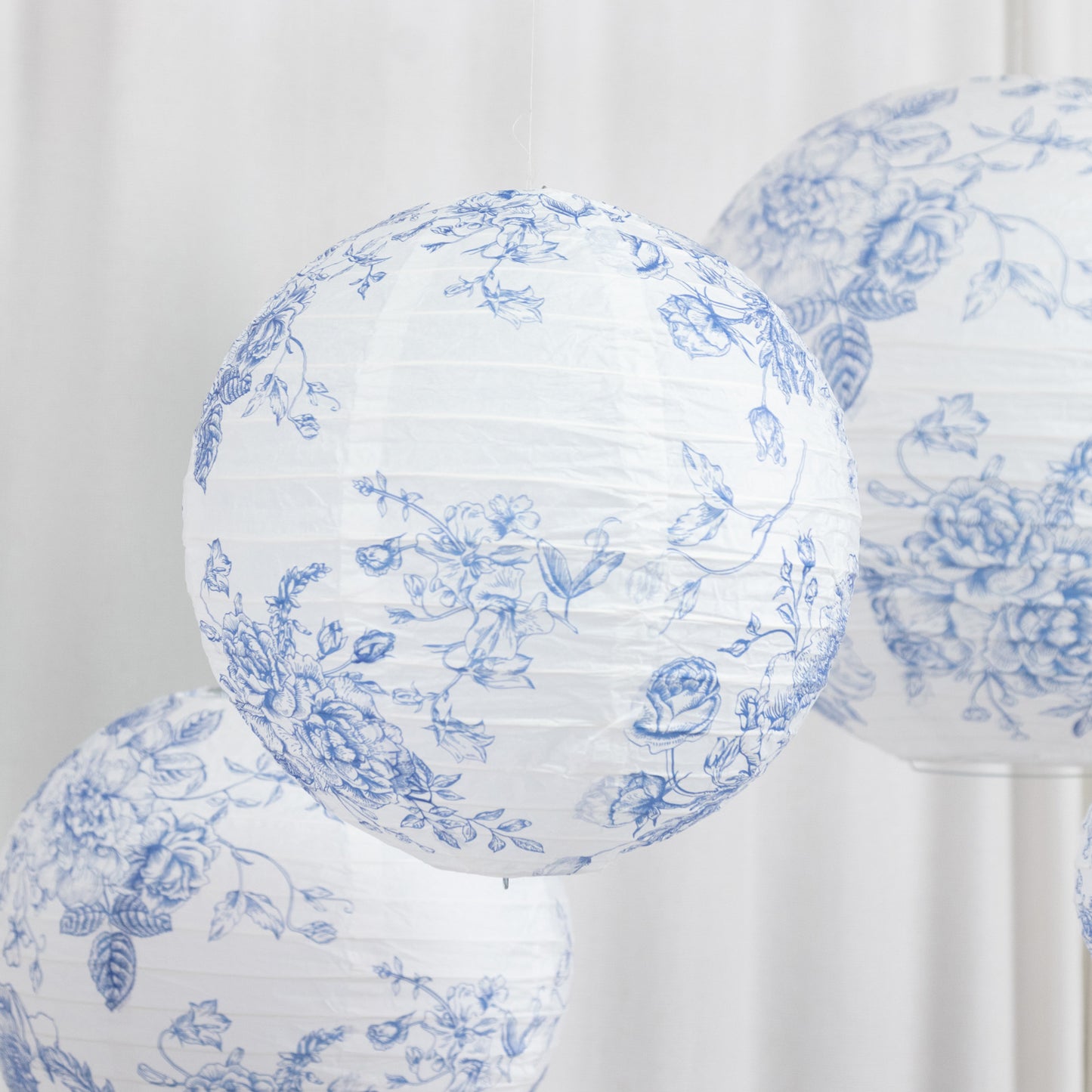 White paper lanterns with blue floral pattern.
