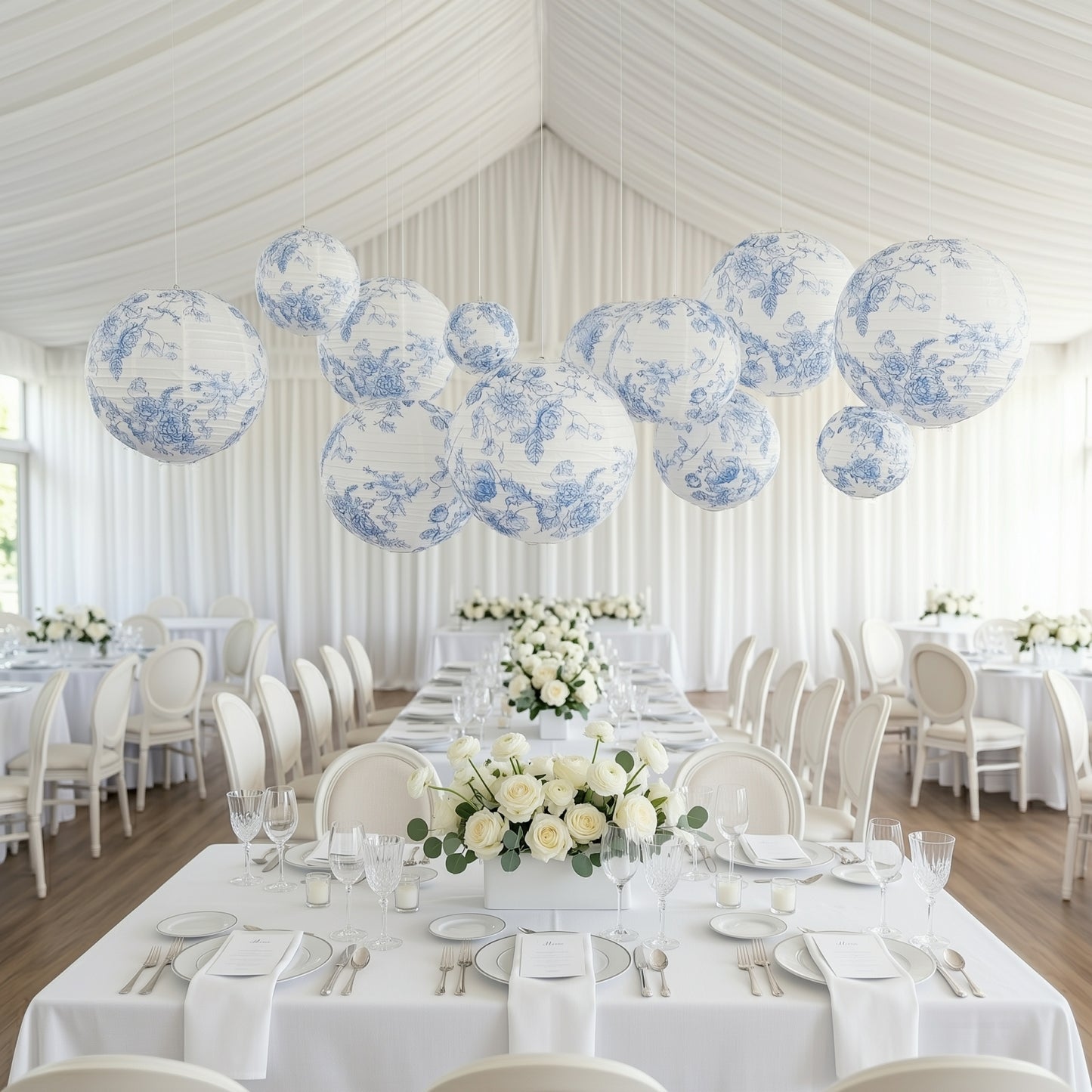 White and blue floral hanging paper lanterns in a decorated dining setting.