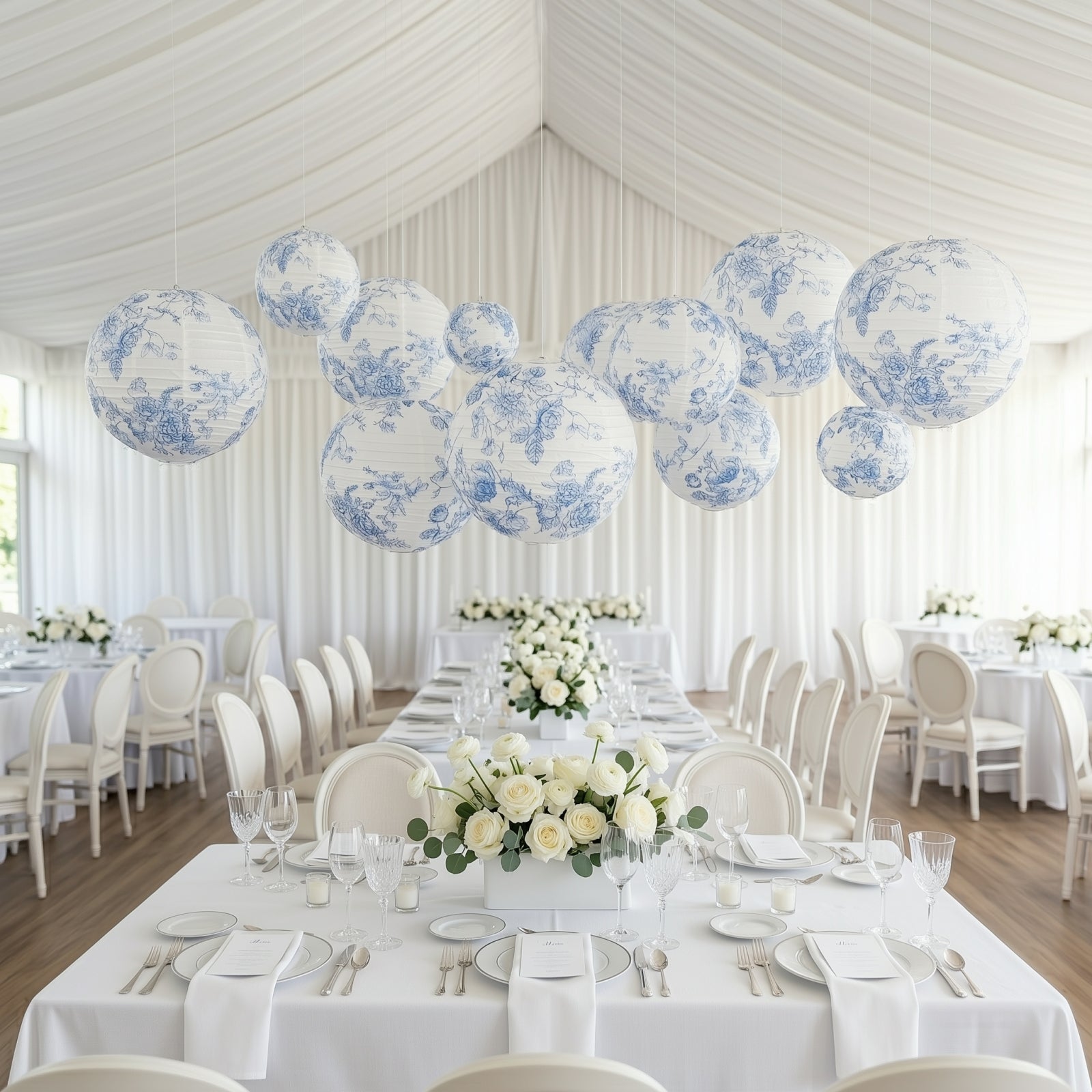 White and blue floral hanging paper lanterns in a decorated dining setting.
