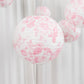 White paper lanterns with pink floral pattern, decorative hanging accents.