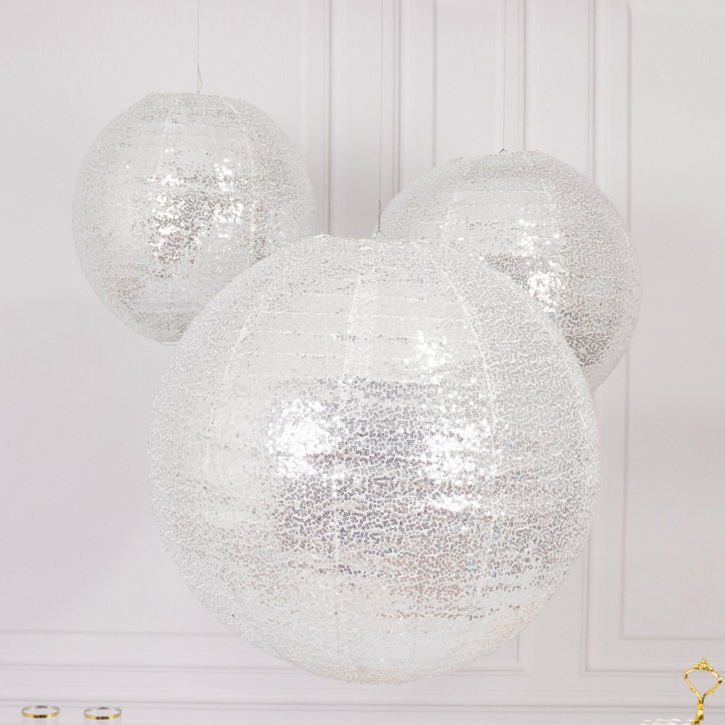 Glitter silver sequin fabric hanging lanterns in large round shapes.