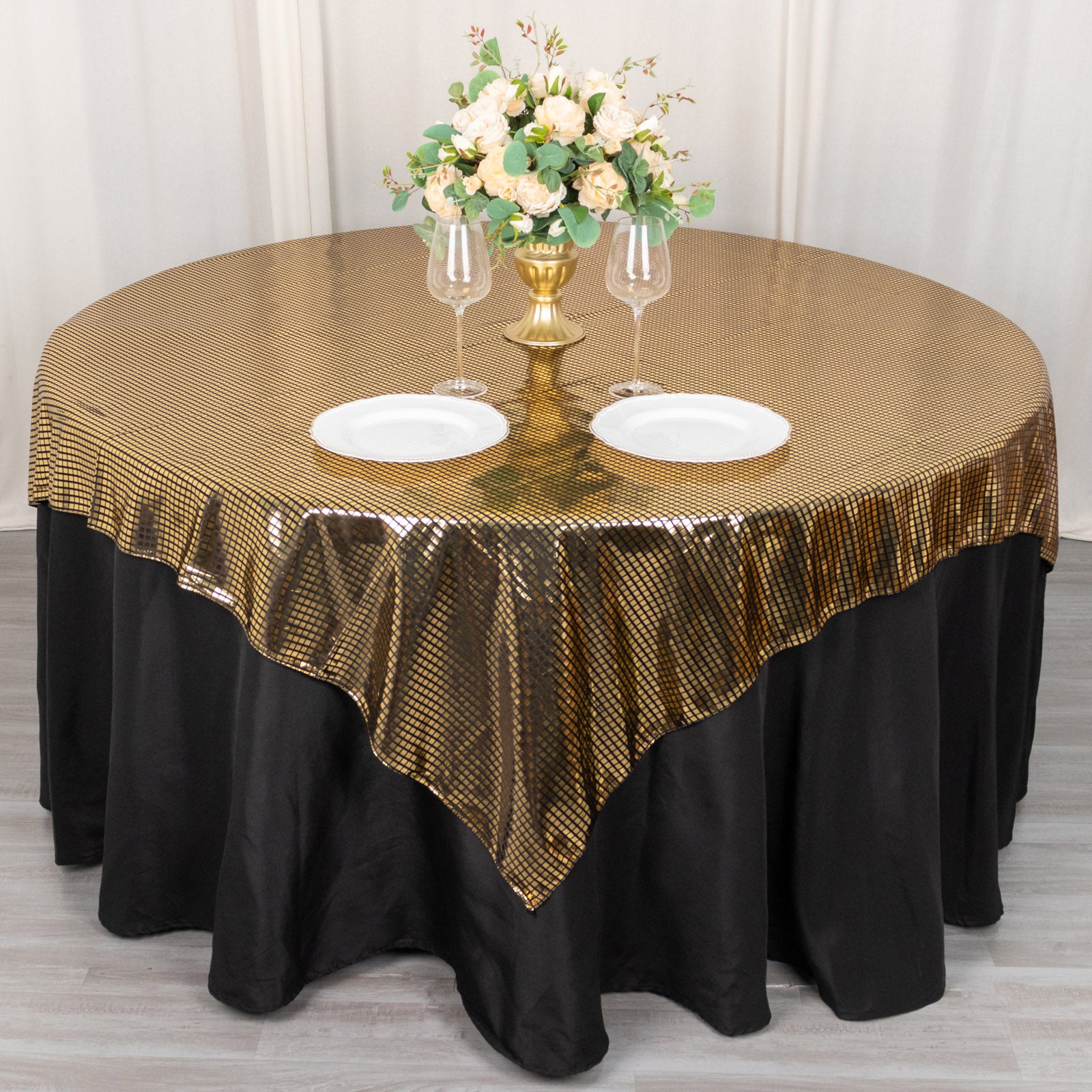 Shiny black and gold foil polyester table overlay for disco theme decor.