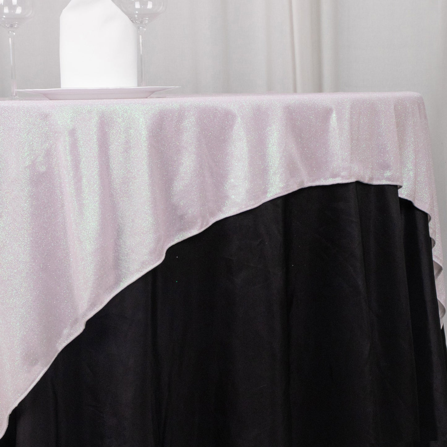 Iridescent glitter sparkle table overlay on a black table.
