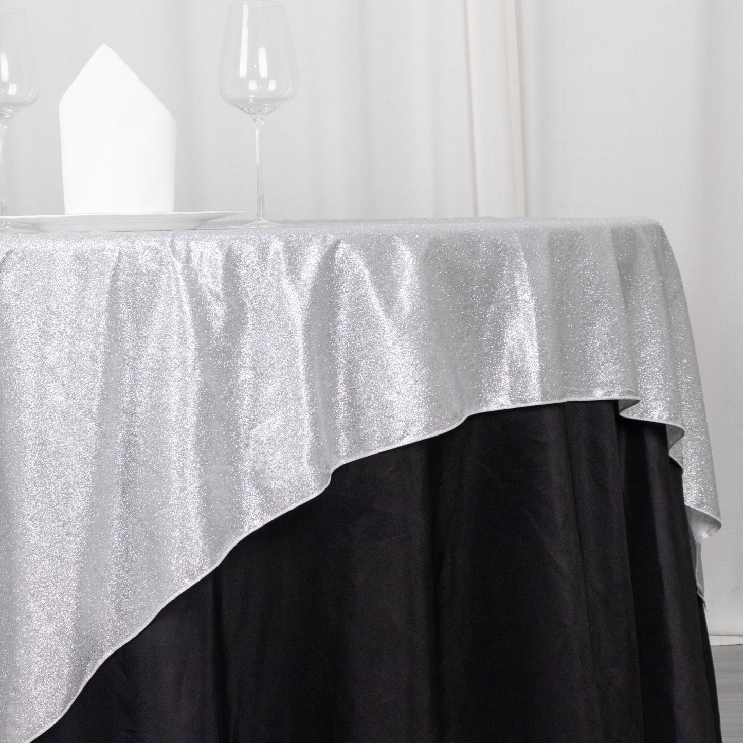 Silver glitter table overlay on a black tablecloth.