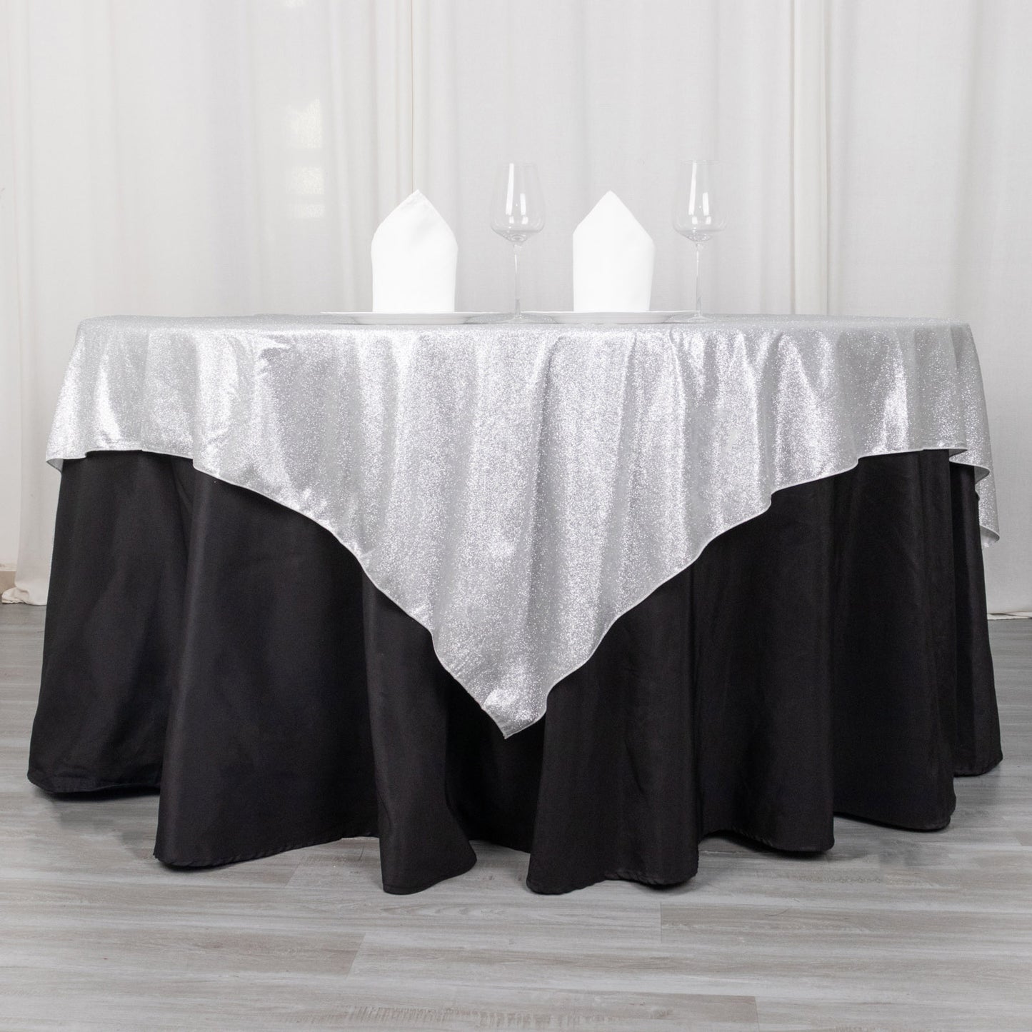 Silver glitter table overlay on a black tablecloth.