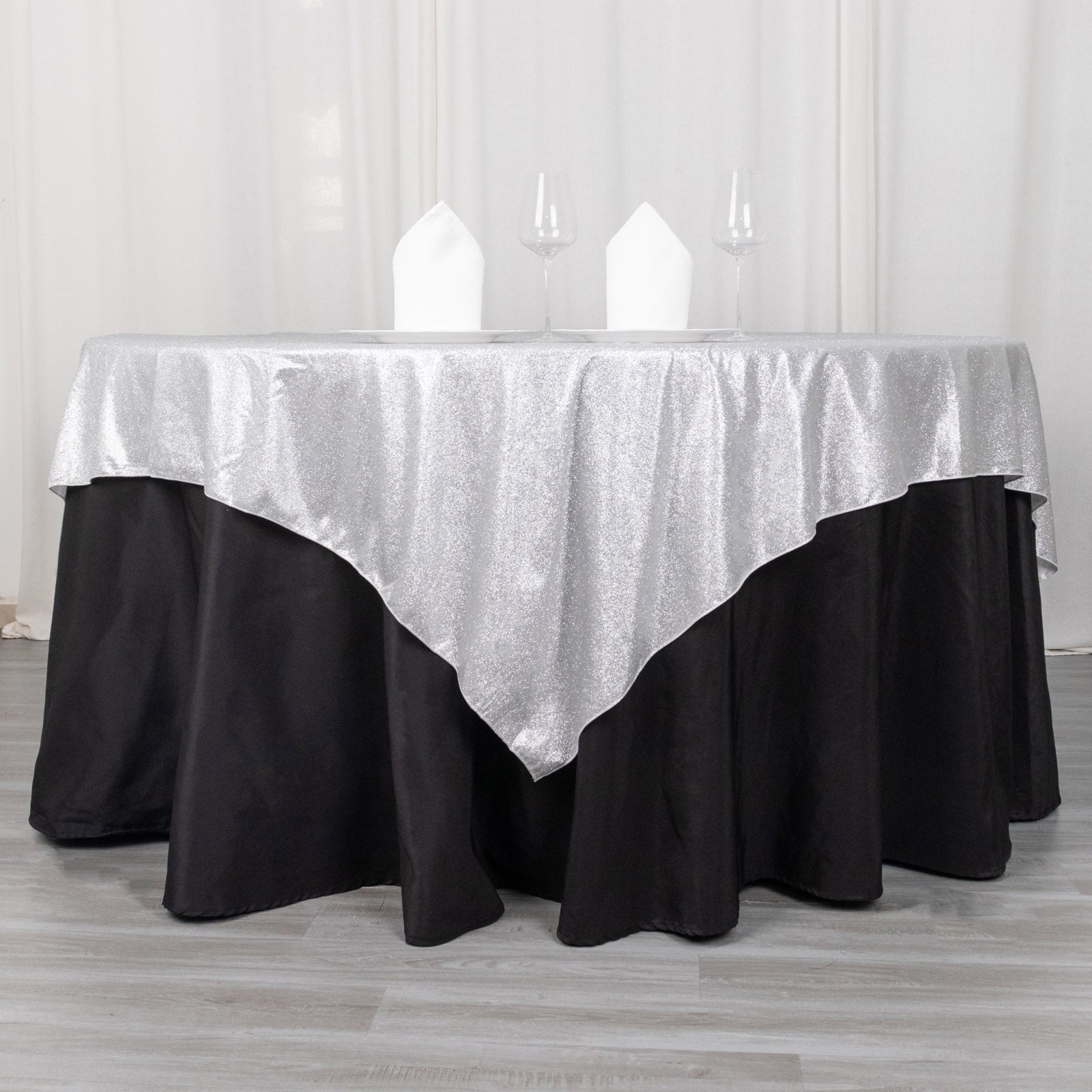 Silver glitter table overlay on a black tablecloth.