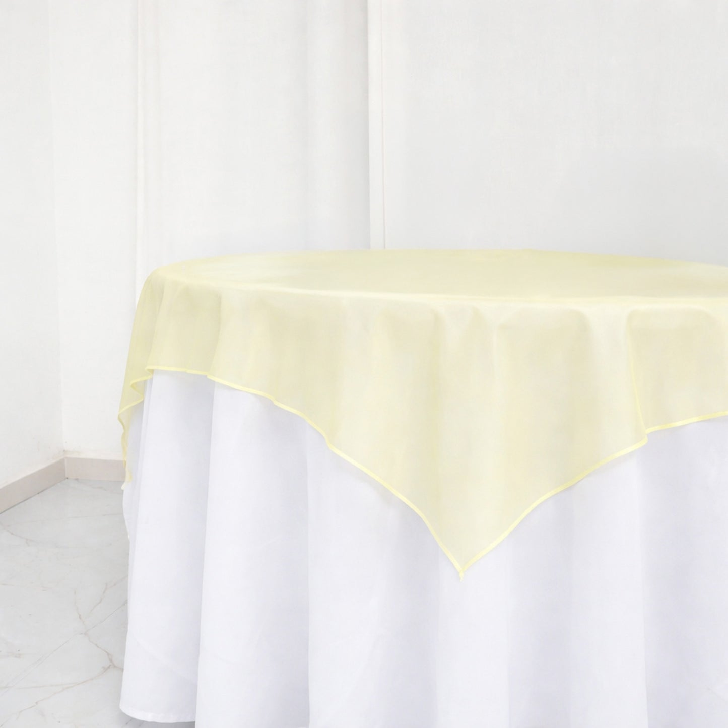 Champagne organza table overlay on a white table, 72"x72".