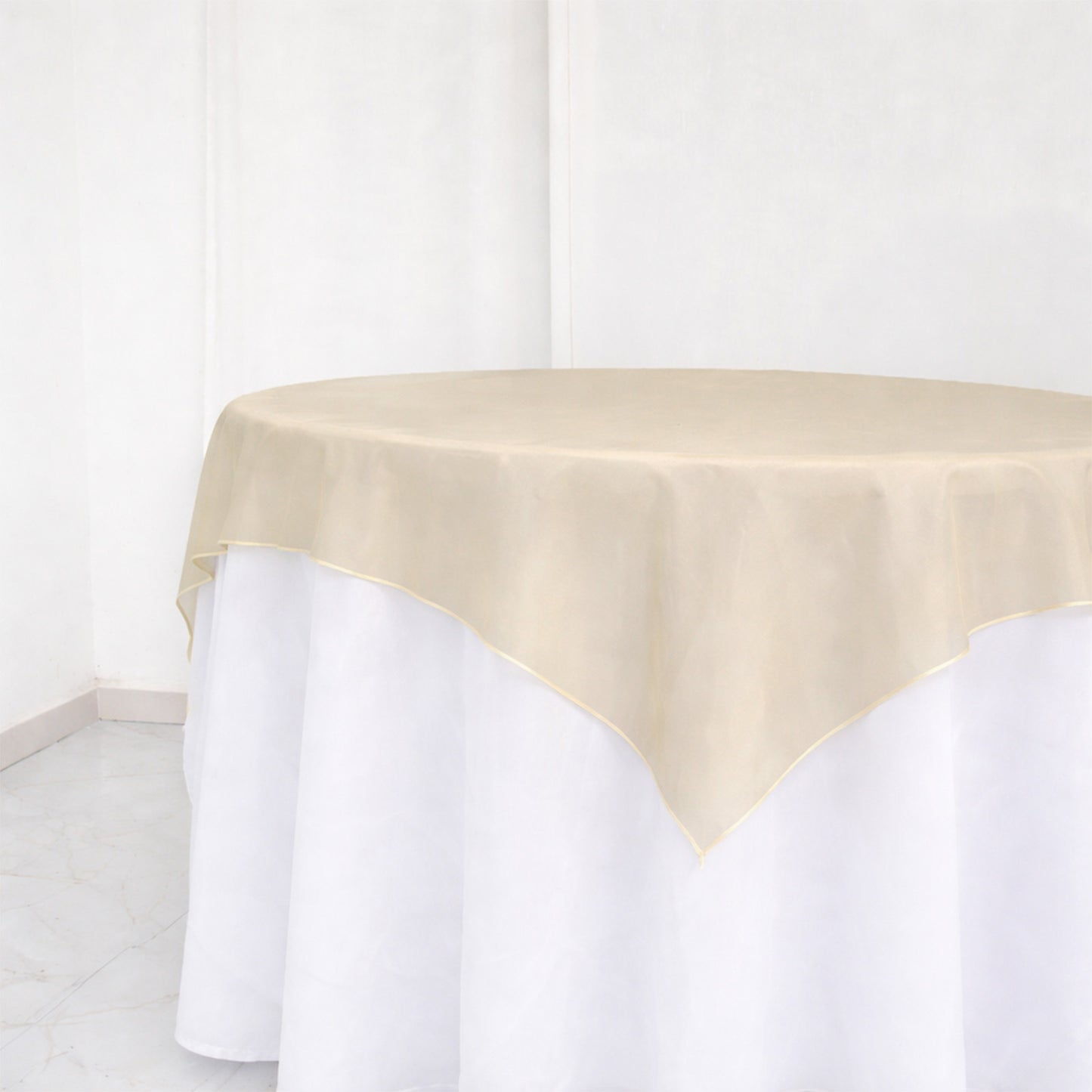 Beige sheer table overlay on a white table.