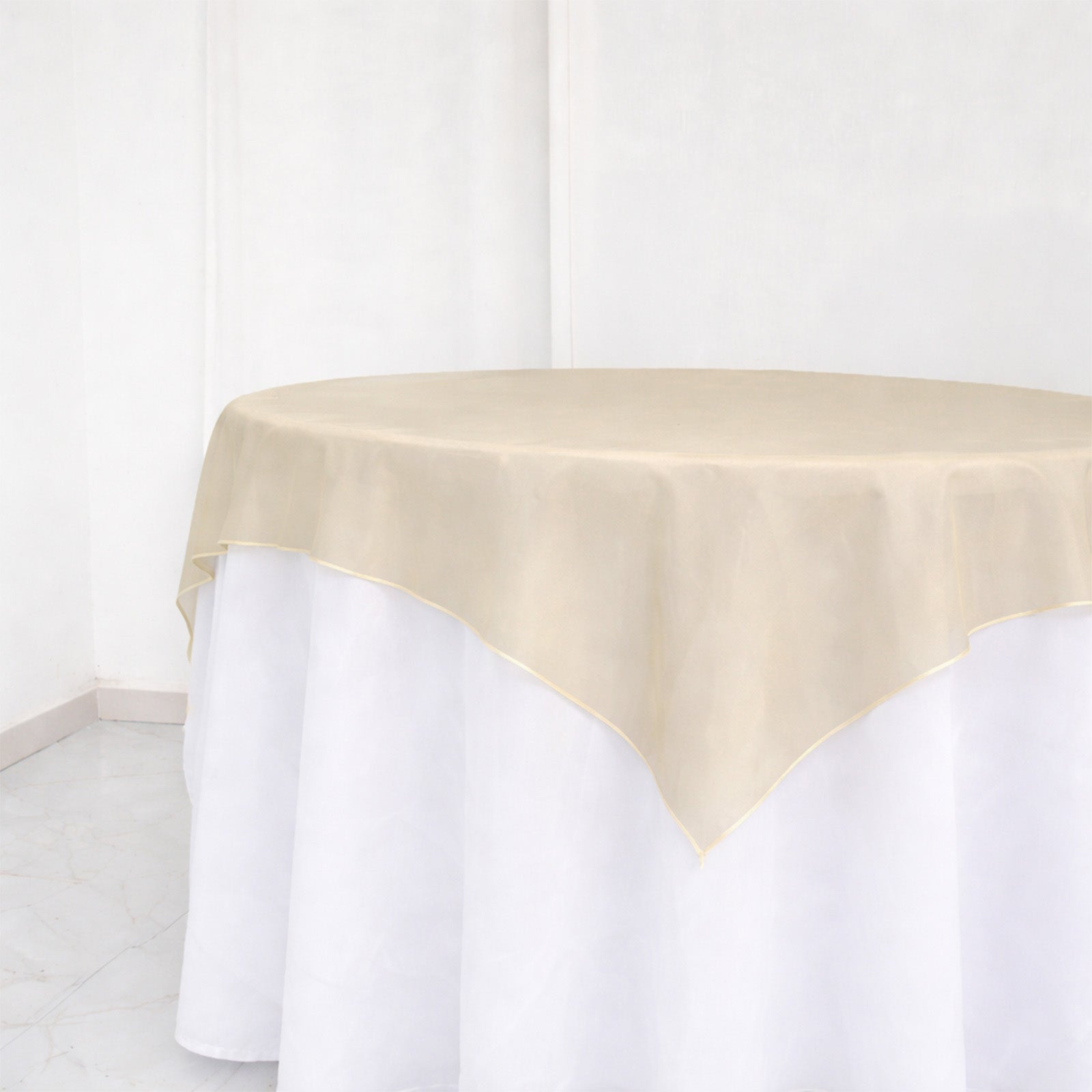 Beige sheer table overlay on a white table.