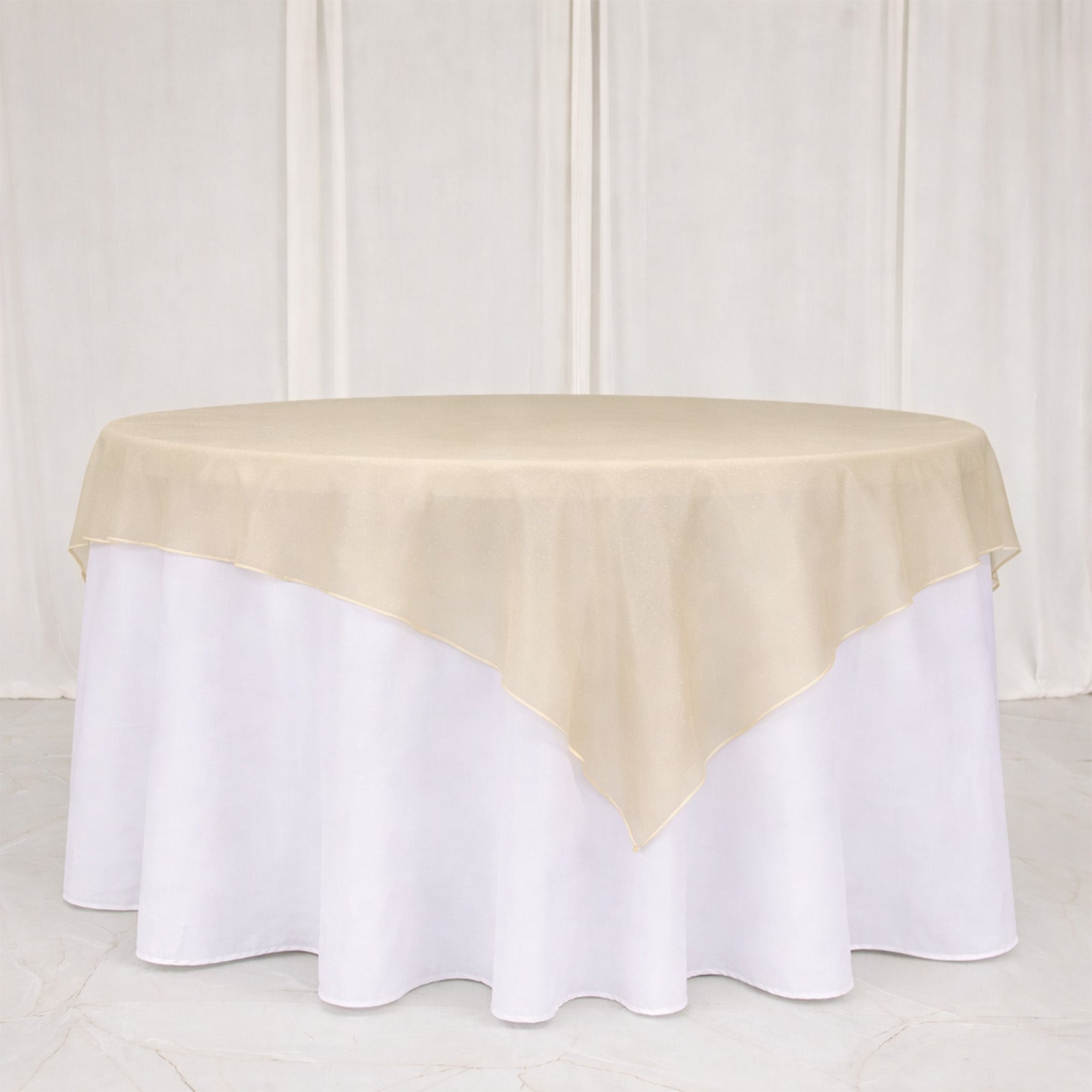 Gold organza table overlay on a white table, 72"x72".