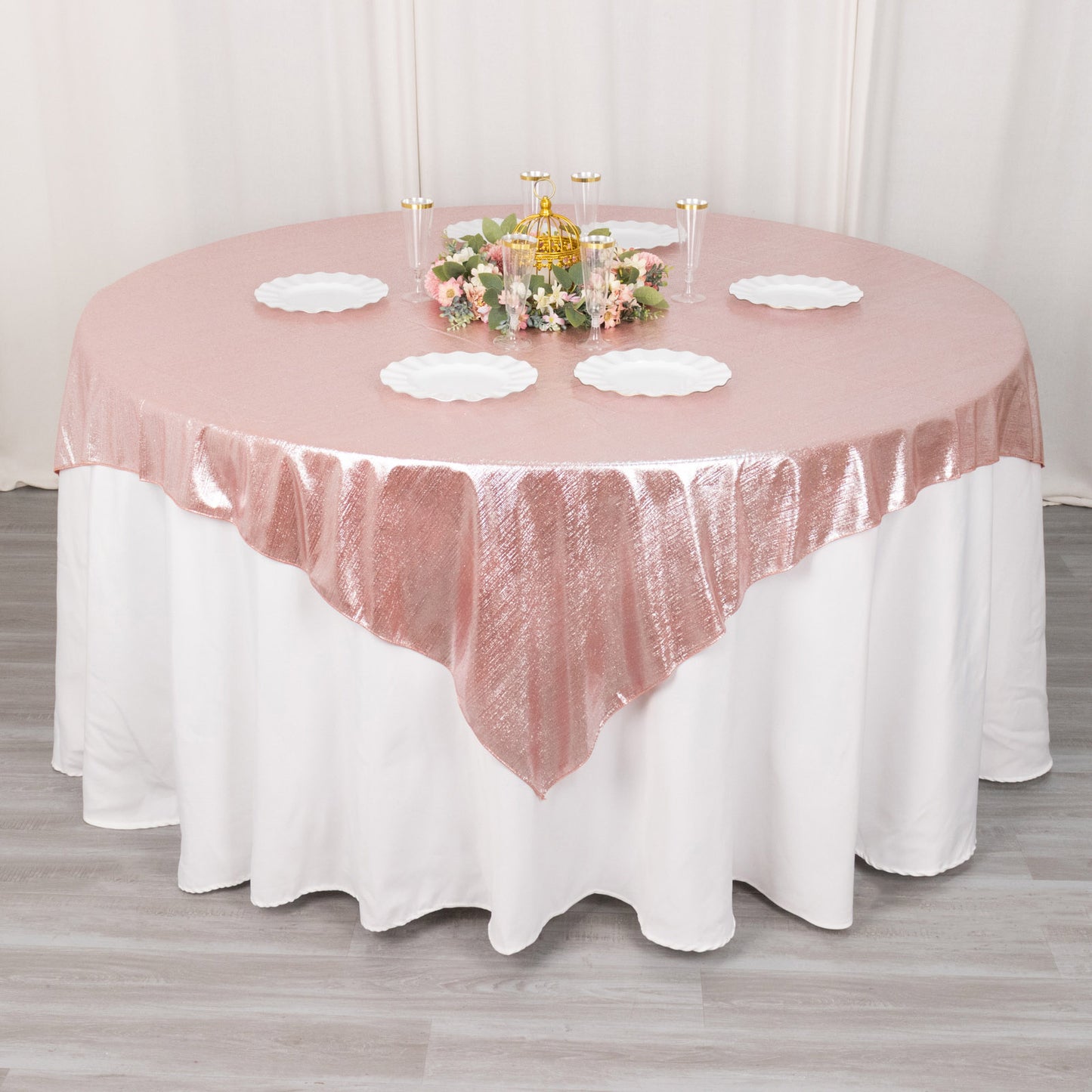 Rose gold shimmer sequin table overlay on a round table setting.