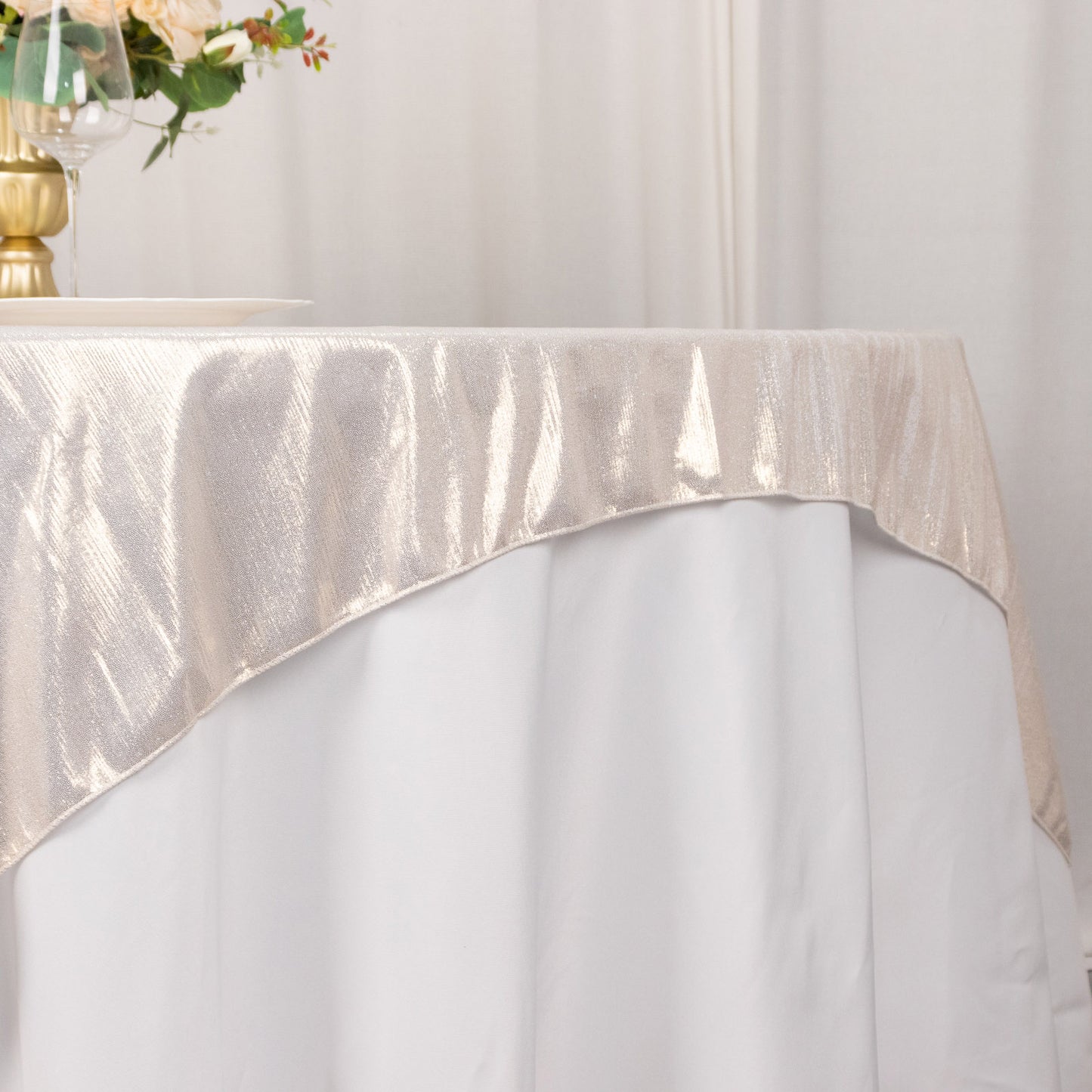 Beige shimmer sequin dots table overlay on a white table.