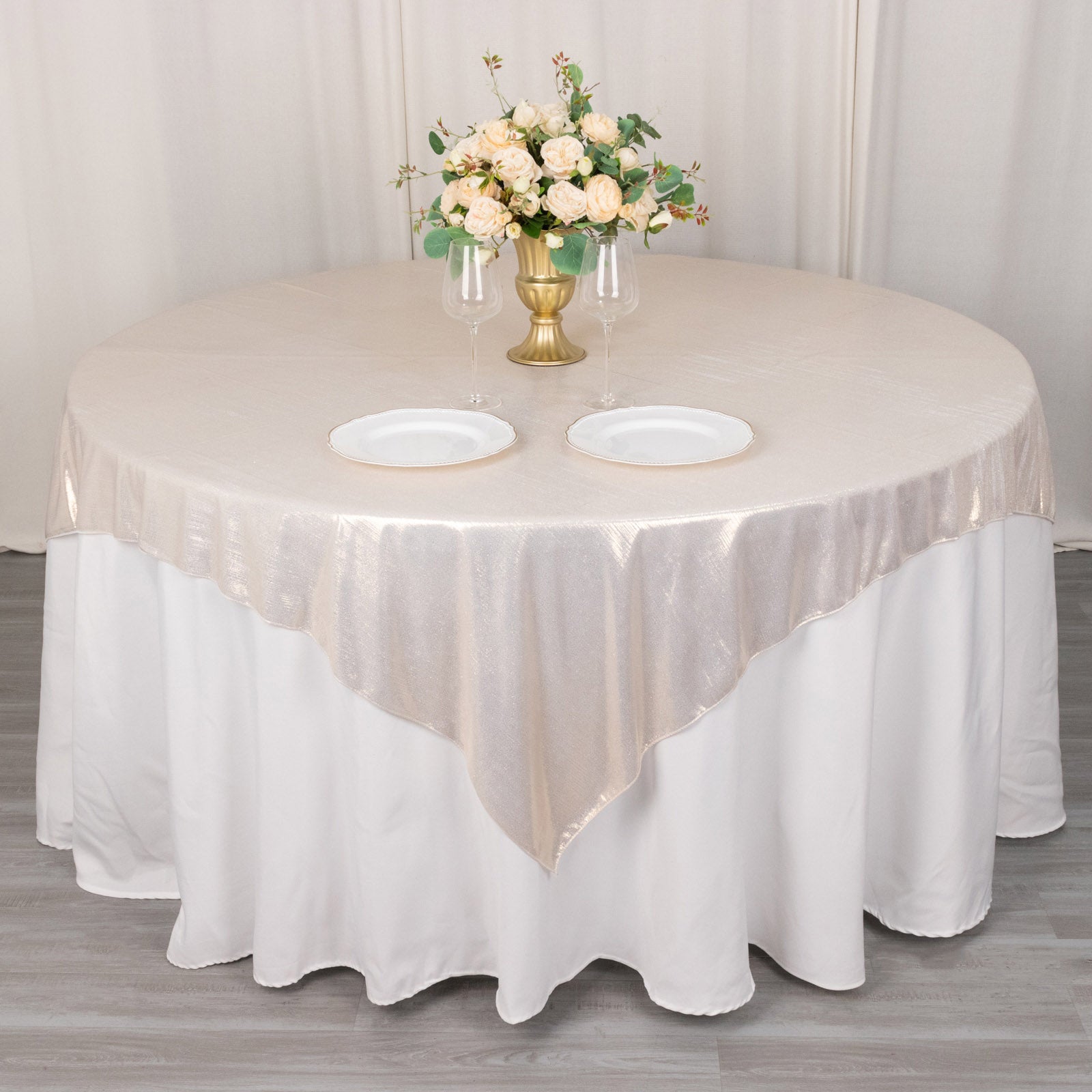 Beige shimmer sequin dots table overlay on a round table with floral centerpiece.