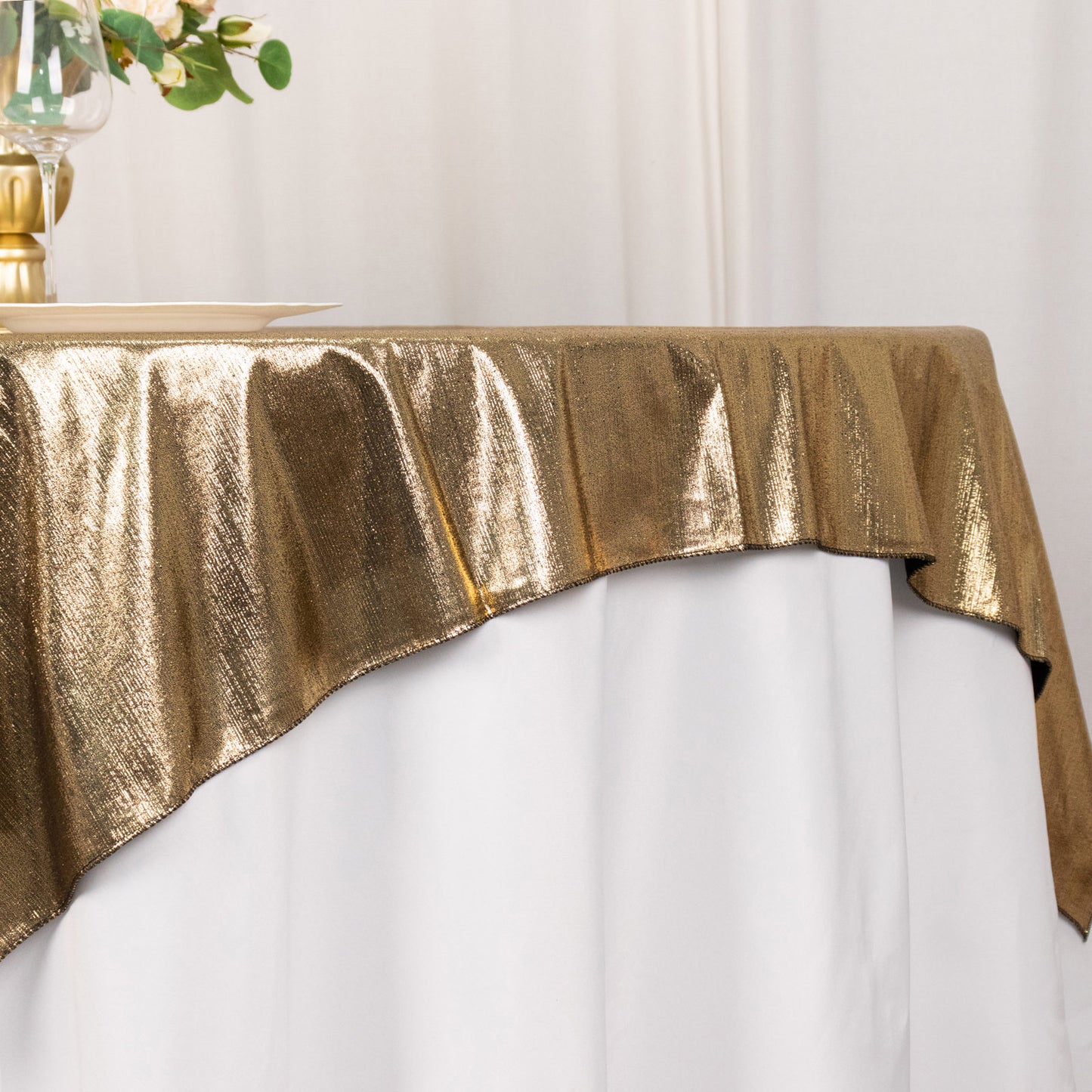 Antique gold shimmer sequin table overlay on a white table.