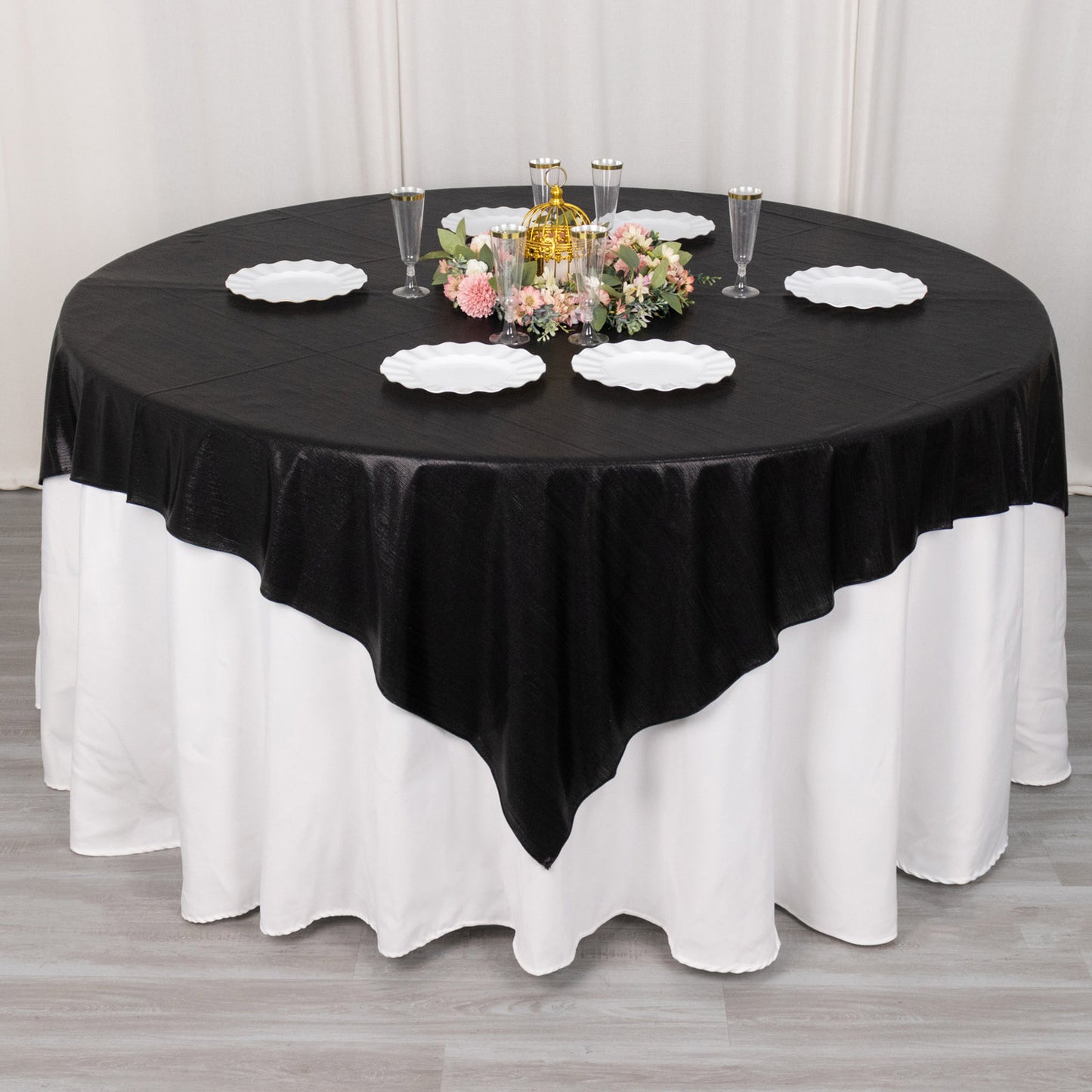 Black shimmer sequin dots table overlay on a round table with floral centerpiece.