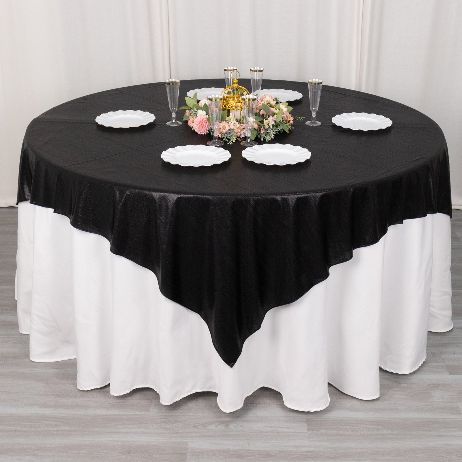 Black shimmer sequin dots table overlay on a round table with floral centerpiece.