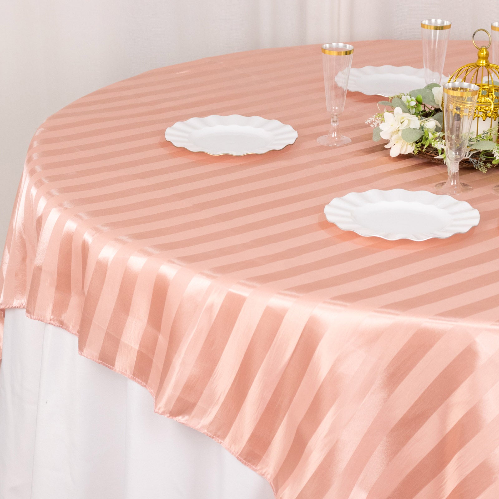 Dusty rose satin stripe table overlay for elegant events.