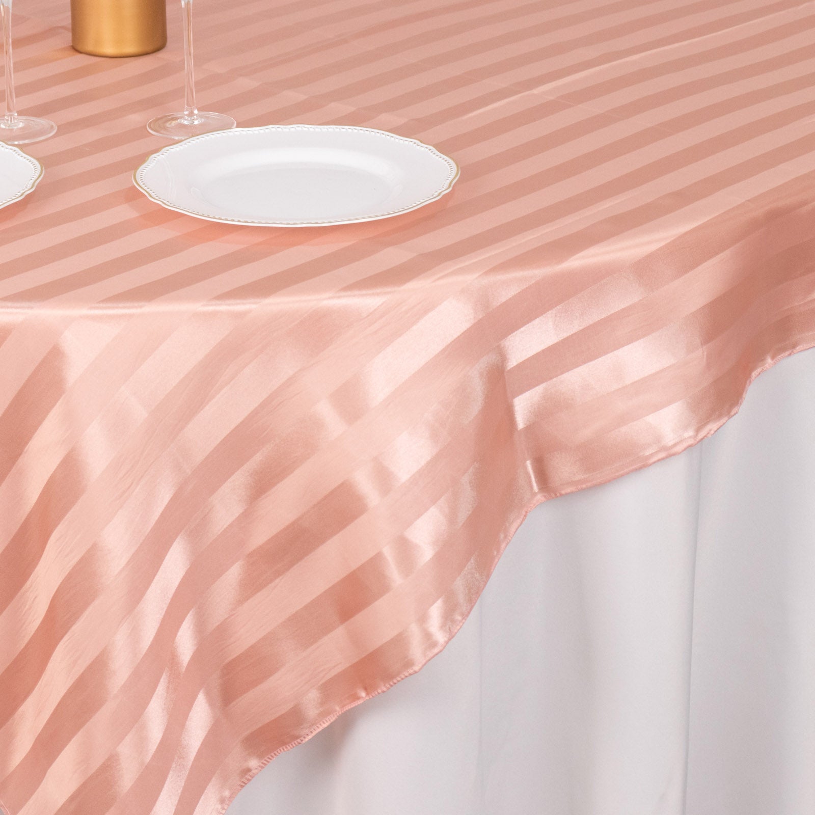 Dusty rose satin stripe table overlay on an elegant table setting.