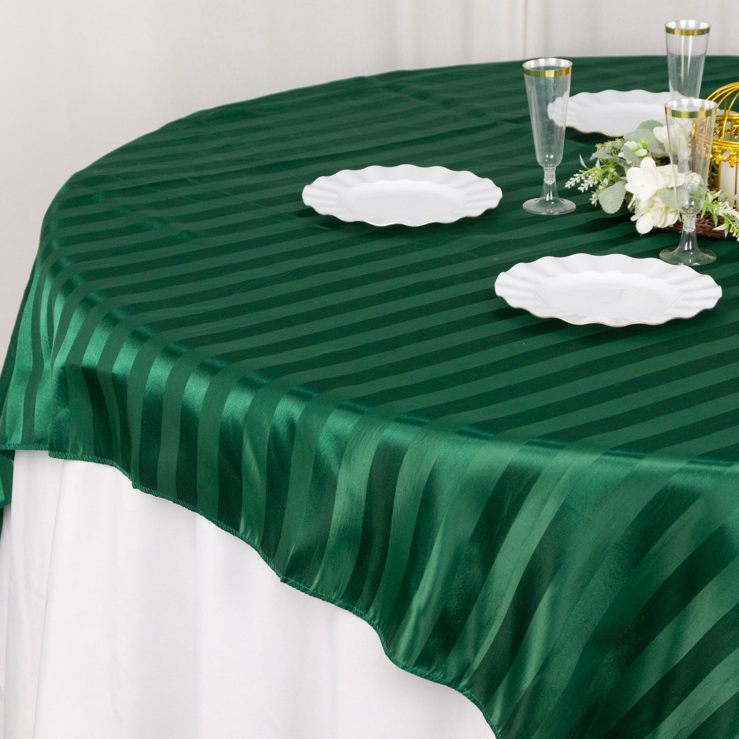 72"x72" Hunter Emerald Green Satin Stripe Table Overlay on a round table.