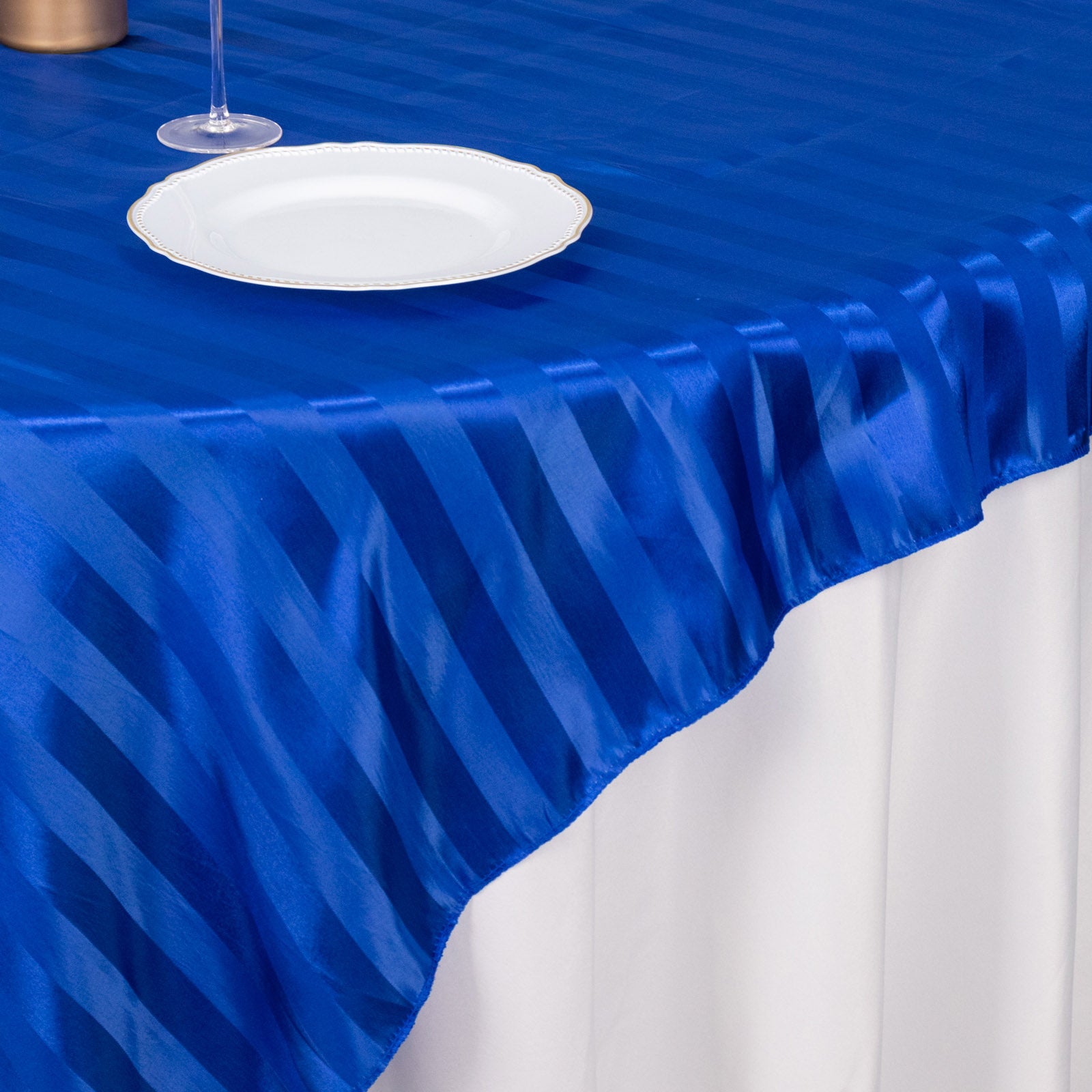 Royal blue satin stripe table overlay on a smooth tabletop.